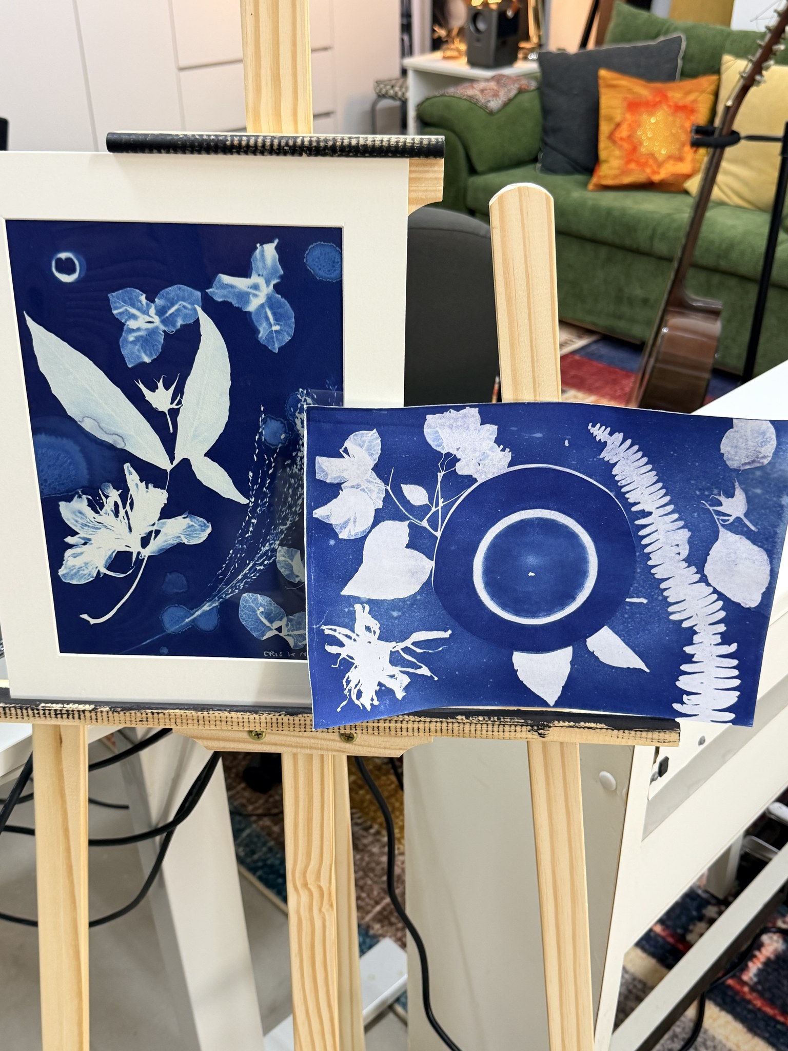 Finished Prussian-blue botanical cyanotype prints on a wooden easel